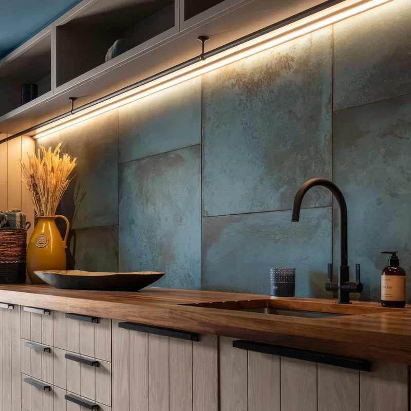 A matte-finished dark bronze faucet with a curved spout and black handles from the chemistry porcelain collection