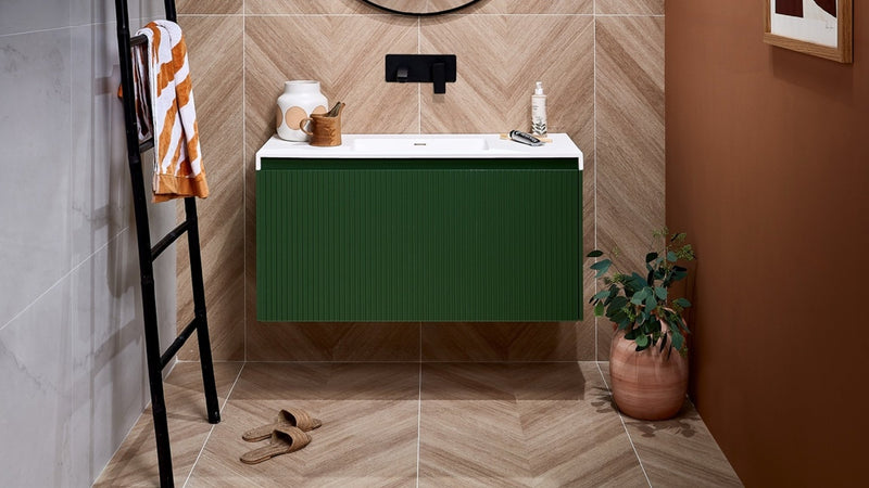 Green ribbed vanity with white countertop and chevron wall tiles highlighting bathroom design features