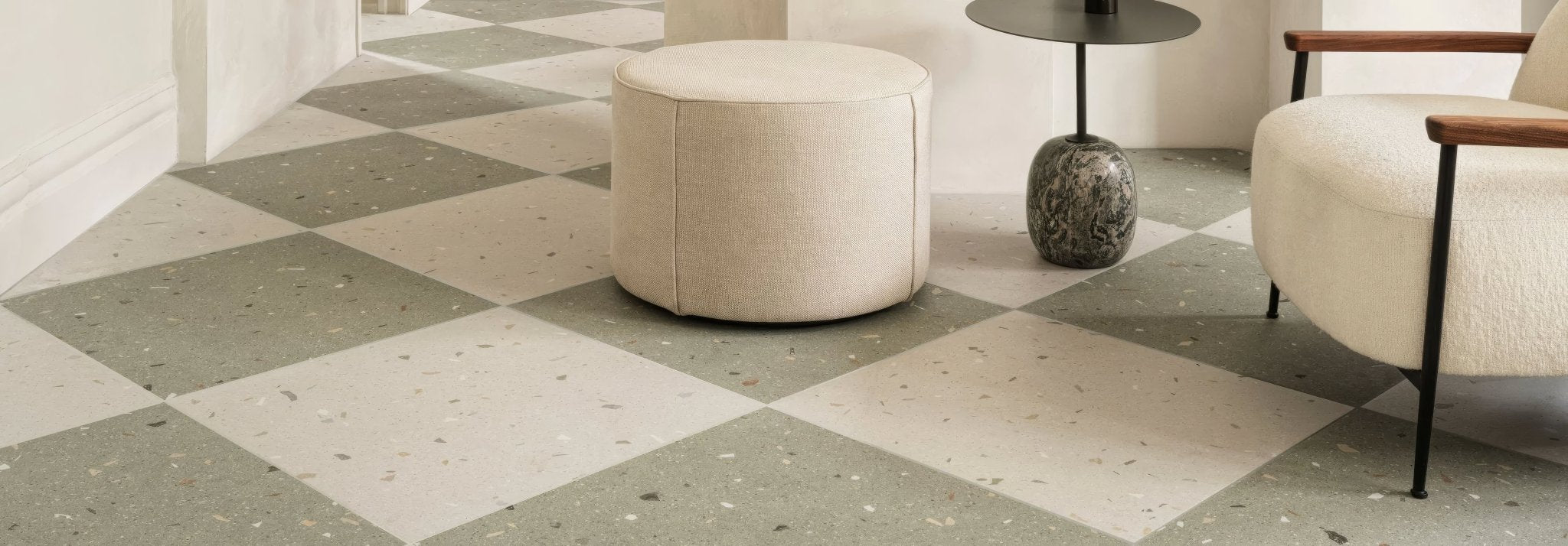 Beige upholstered round ottoman with soft textured fabric finish from the confetti collection