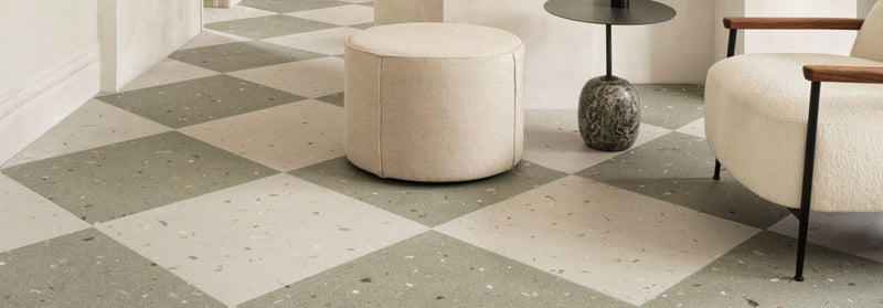 Beige upholstered round ottoman with soft textured fabric finish from the confetti collection
