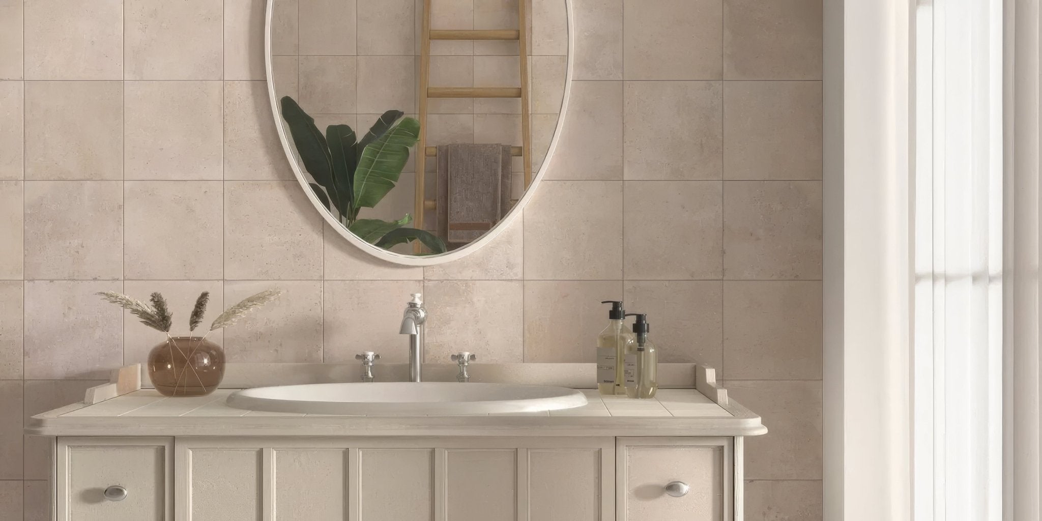 White oval mirror with thin light-colored frame reflecting green foliage and wooden ladder from cotto porcelain tile collection