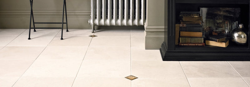 Cream-colored ceramic floor tiles with subtle gold diamond inlays from dorzano tiles collection