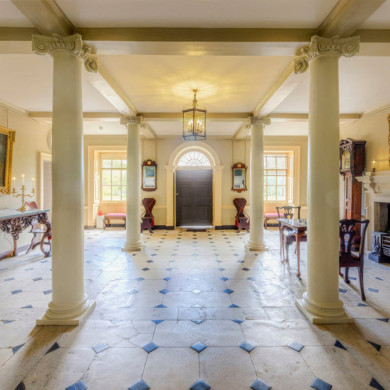 The grand hallway with tall cream-colored limestone columns featuring ornate capitals in english heritage limestone collection