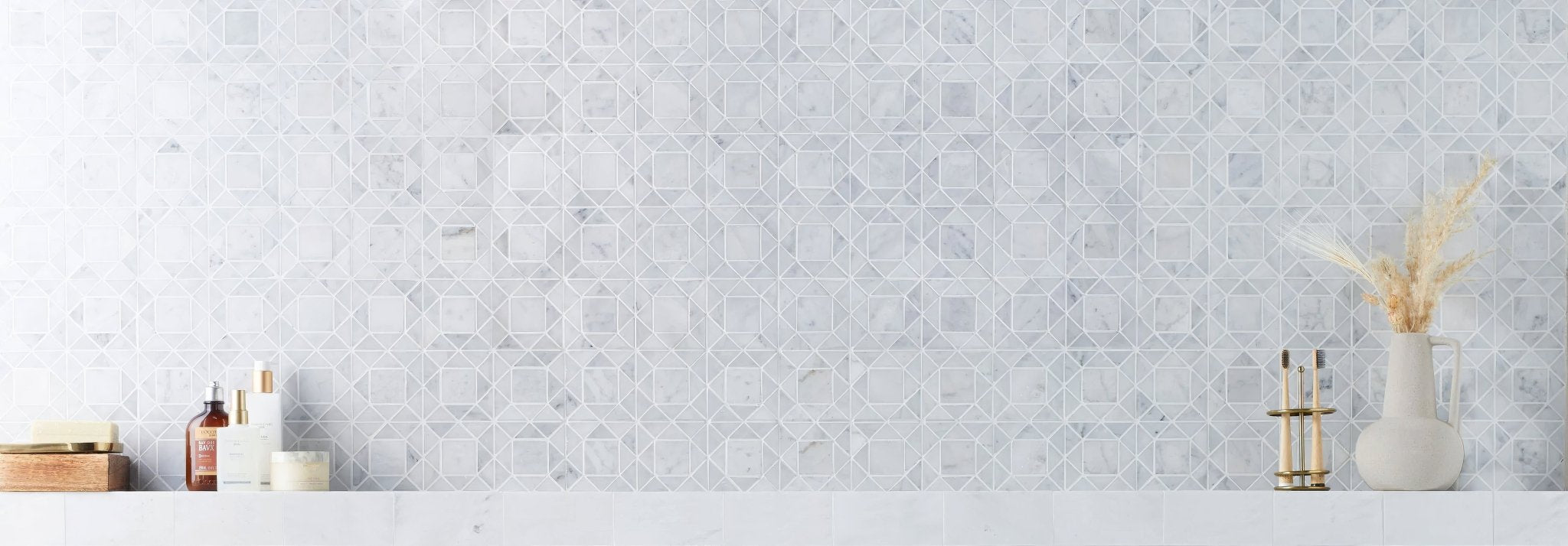 The wall features light gray geometric pattern mosaic tiles from the fired earth wall tiles collection