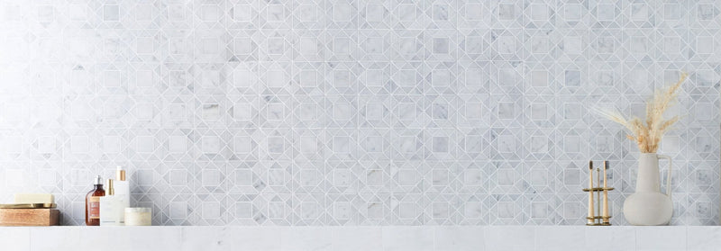 The wall features light gray geometric pattern mosaic tiles from the fired earth wall tiles collection