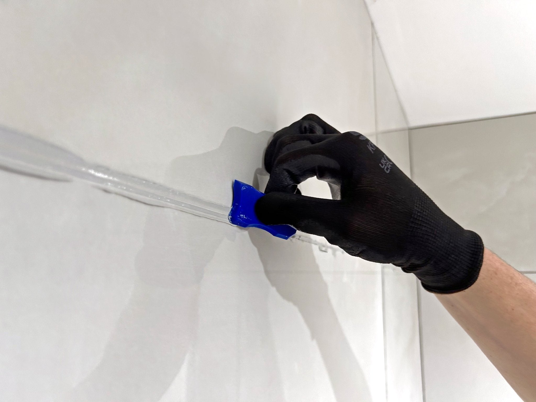Blue plastic tile spacers used to separate white tiles in fixing and grouting materials collection