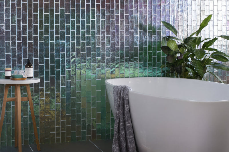 White freestanding bathtub with sleek modern design and smooth surface in glass bathroom tiles collection