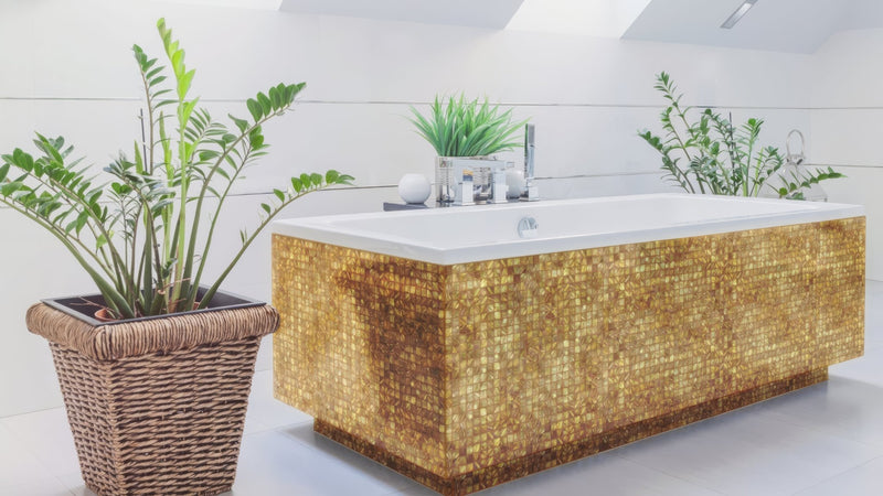 Golden mosaic tiled bathtub with sleek white interior and modern chrome fixtures in gold bathroom tiles collection
