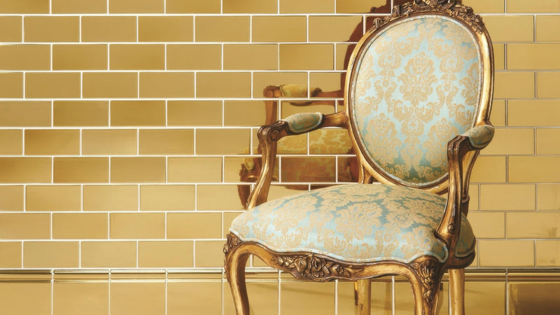 Antique gold-framed chair with light blue damask upholstery displayed in gold wall tiles collection