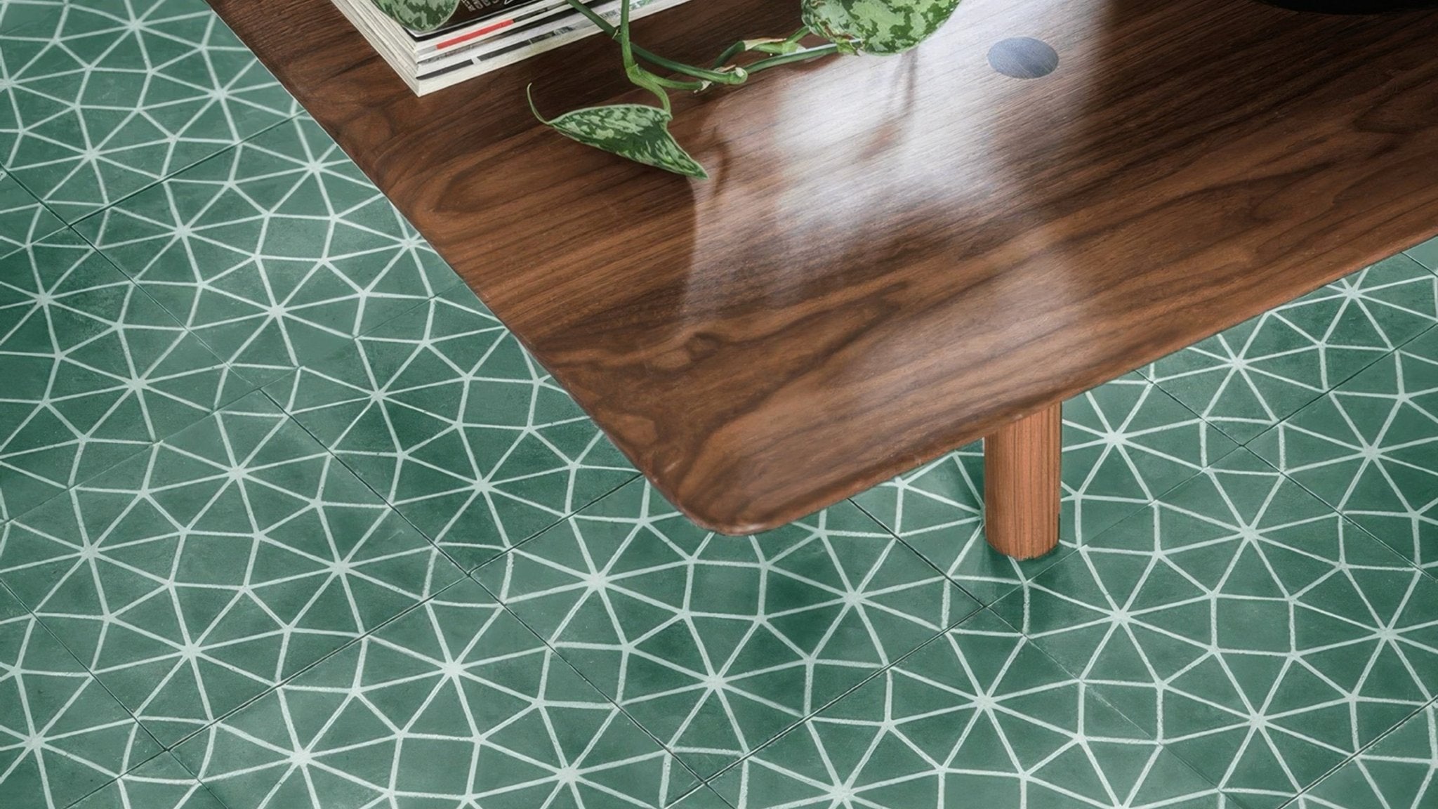 A polished dark wood table with visible grain and a smooth reflective surface in the green floor tiles collection