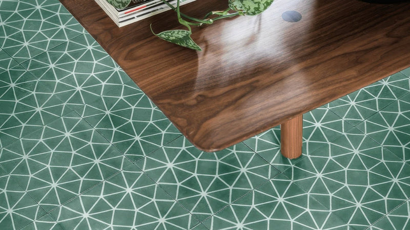 A polished dark wood table with visible grain and a smooth reflective surface in the green floor tiles collection