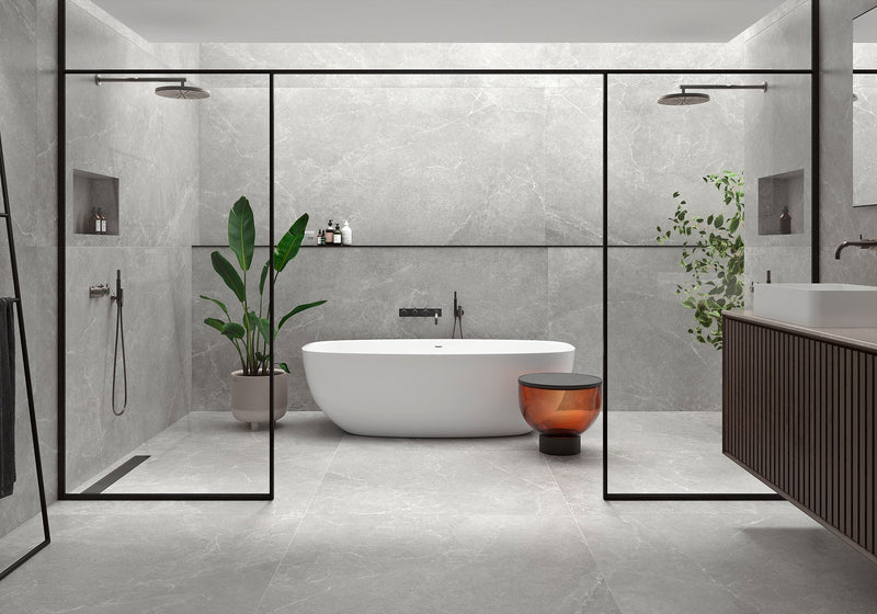 A sleek freestanding white bathtub with minimalist design in a bathroom featuring grey bathroom tiles.