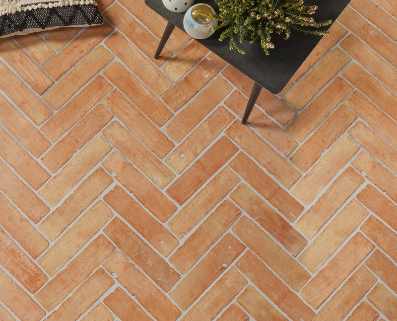 Terracotta rectangular terracotta floor tiles arranged in a herringbone pattern in a herringbone floor tiles collection