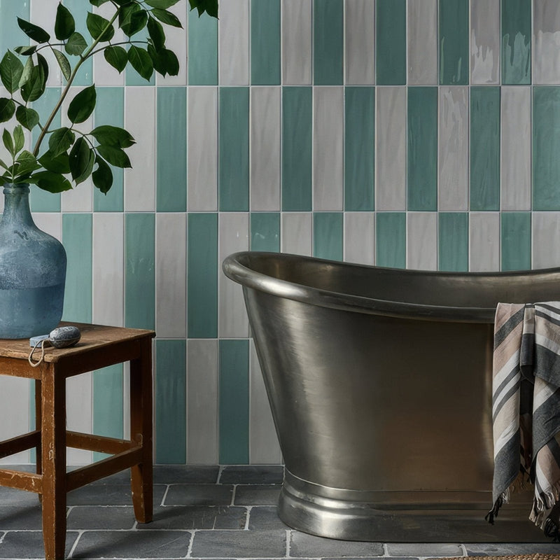 A sleek metallic freestanding bathtub with brushed finish and curved design from the Kennet Porcelain collection