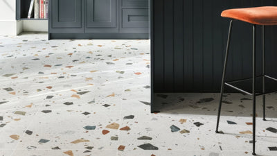 Terrazzo kitchen floor tiles with light gray base and colorful stone fragments in black brown orange green and beige