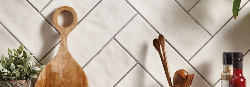 A light brown wooden cutting board with a smooth polished surface and circular handle from the landscape tile collection