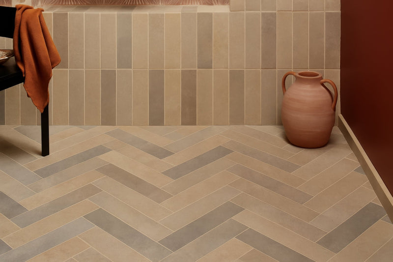 Terracotta ceramic pitcher with dual handles and rounded body displayed with limestone bathroom tiles backdrop