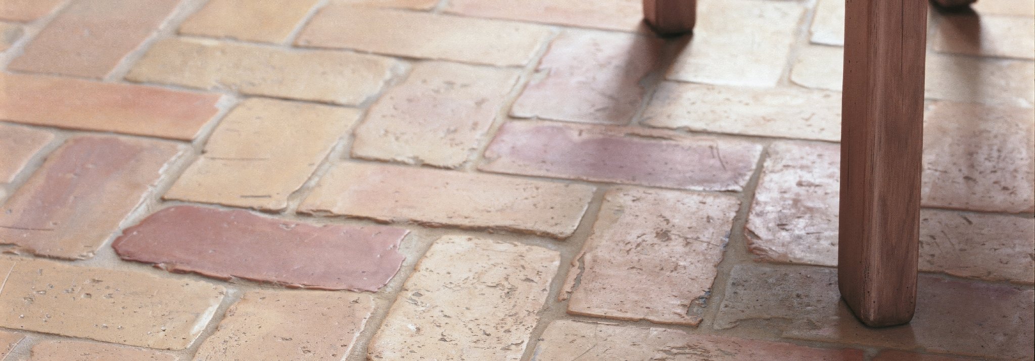 Terracotta-colored rustic stone tiles with uneven surface and natural hue variations from the lubelska brick collection