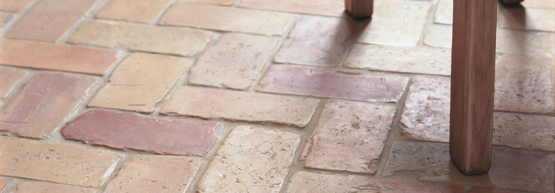 Terracotta-colored rustic stone tiles with uneven surface and natural hue variations from the lubelska brick collection