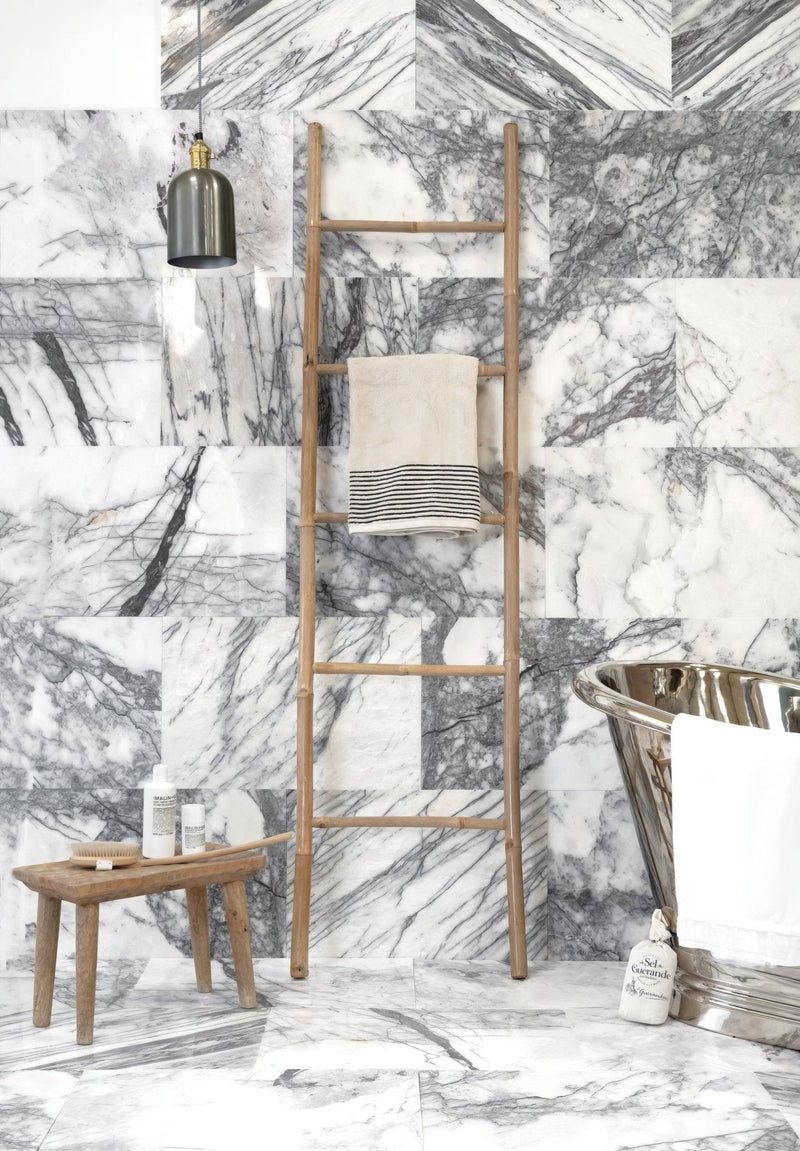 A slender light brown wooden ladder with evenly spaced rungs and natural finish featured in marble tiles collection