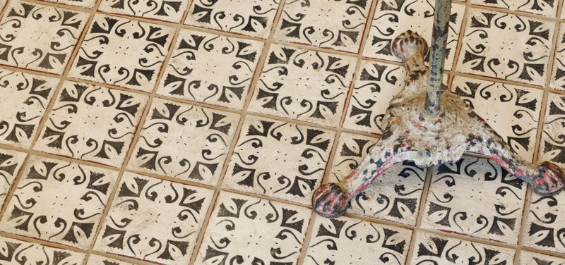 Weathered bronze cast iron table leg with ornate scrollwork from the marrakech tile collection