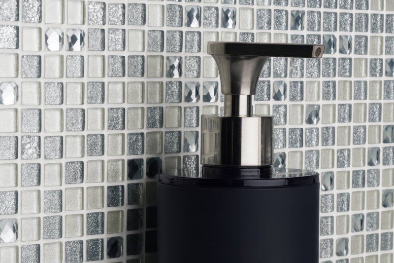 Black cylindrical soap dispenser with sleek metallic pump in a metallic mosaic tiles collection