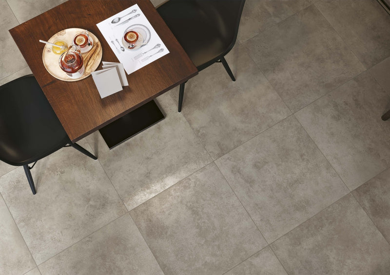 Wooden table with black chairs and a set meal showcasing Minoli concrete look tiles floor design