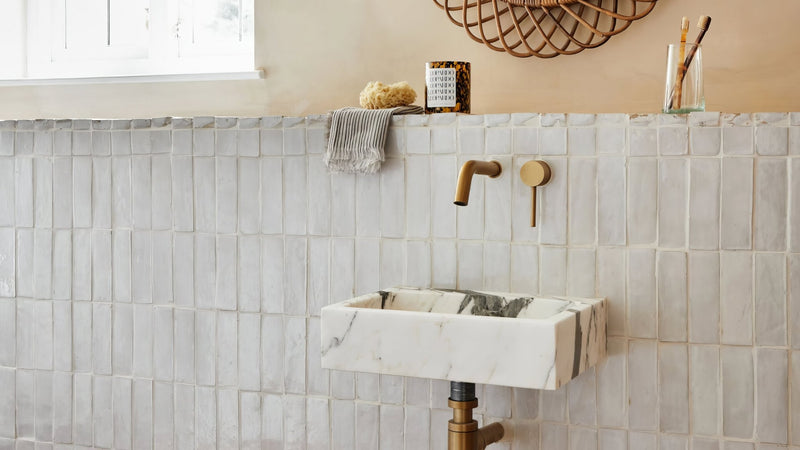 White marble sink with gray veining and gold-toned faucet in moroccan bathroom tiles collection.