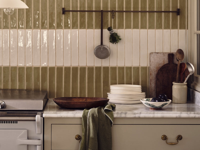 A dark brown wooden bowl with a smooth polished finish on a marble countertop from Nina Campbell Rivage collection