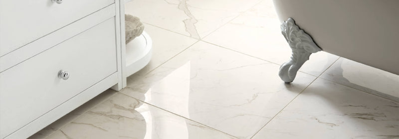 A white claw-foot bathtub with ornate sculpted feet in the north beach tiles collection