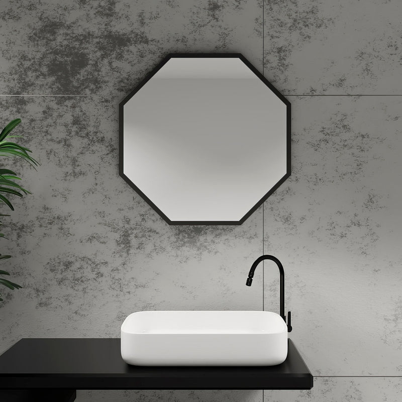 Black octagonal mirror with sleek modern frame mounted above white rectangular sink in octagon mirrors collection