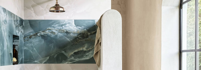 The bathroom features a blue and white marble wall panel from the Onyx Porcelain Tiles collection with swirling patterns.