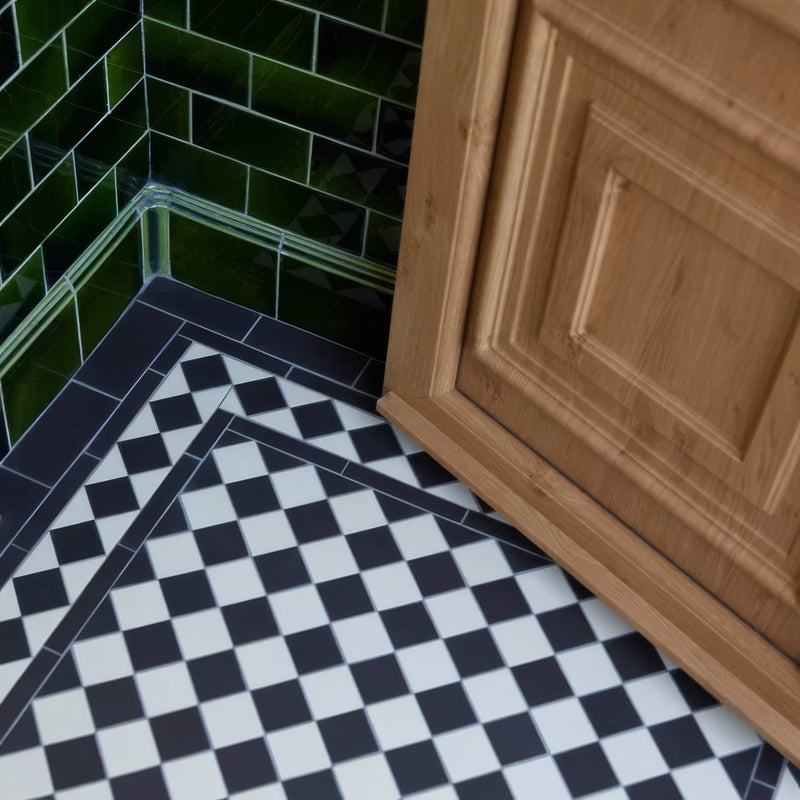 Black and white checkered oxford floor tiles 106 x 106mm with dark blue border and green subway wall tiles background
