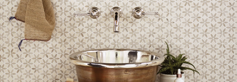 Shiny copper-colored vessel sink with polished chrome faucet and handles from palazzo tiles collection