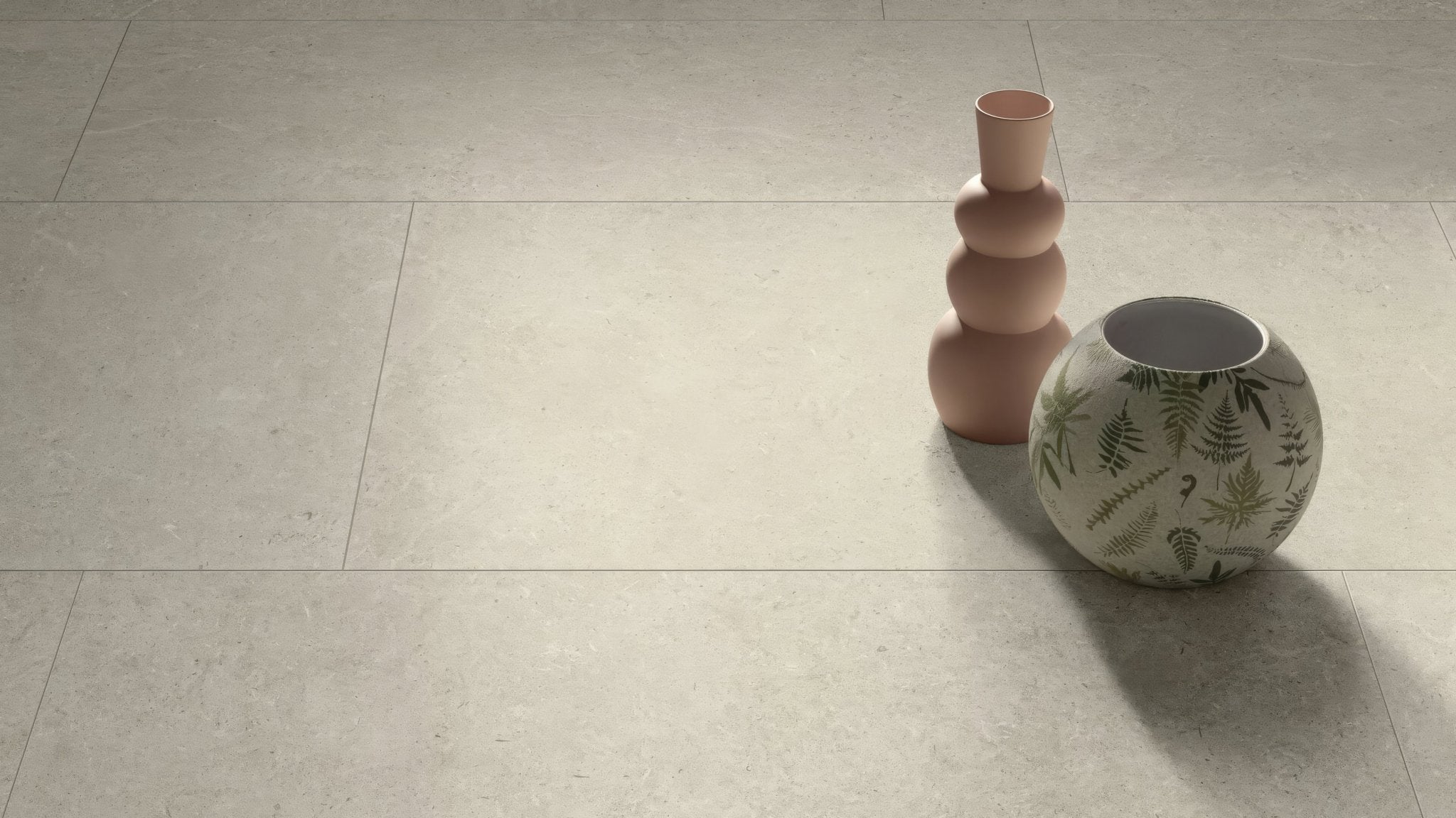 A round ceramic vase with white base and green fern patterns beside a taller terracotta stacked vessel in rectangle kitchen tiles collection