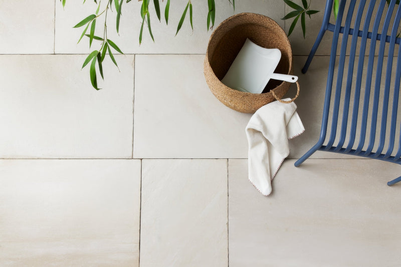 A white rectangular sandstone bathroom tile with a matte finish arranged in a clean floor grid pattern