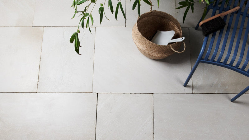 A woven wicker basket with natural earthy tone and visible texture in sandstone kitchen tiles collection