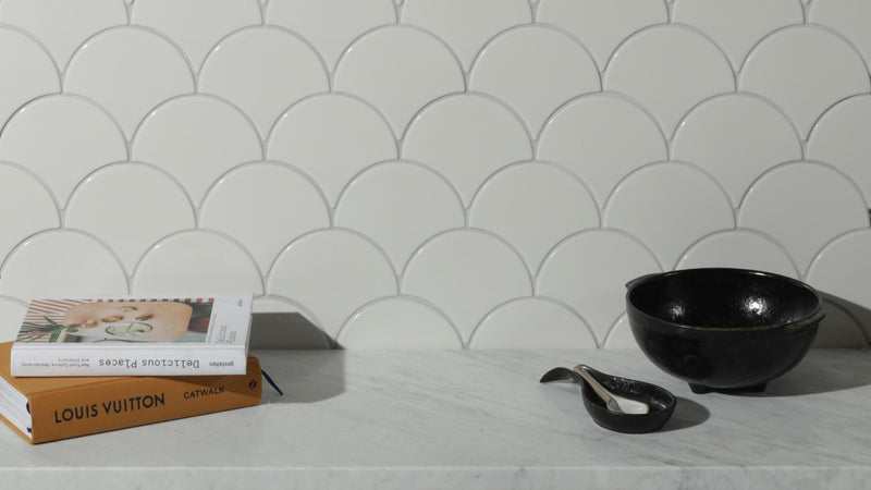 Black ceramic bowl with glossy finish and three small feet from scallop kitchen tiles collection
