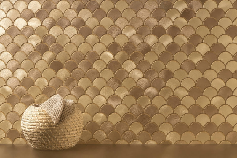 A woven beige basket with a textured handcrafted appearance against metallic gold scallop mosaic tiles backdrop.