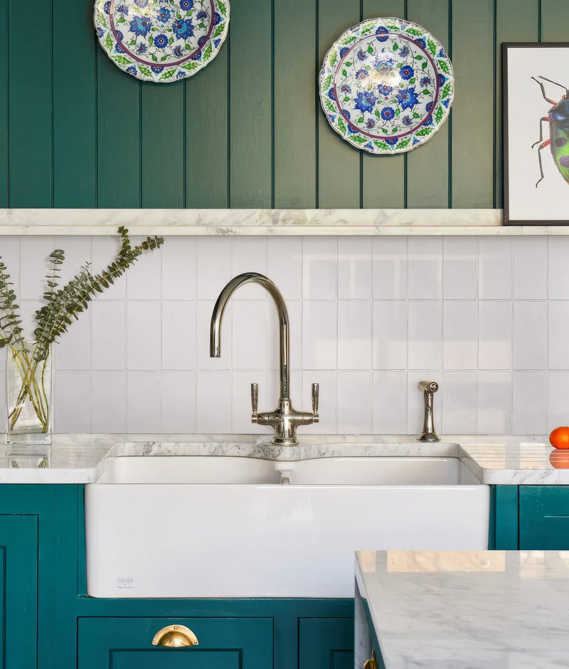 White farmhouse ceramic sink with polished chrome faucet and matching sprayer from the shoreline ceramic collection