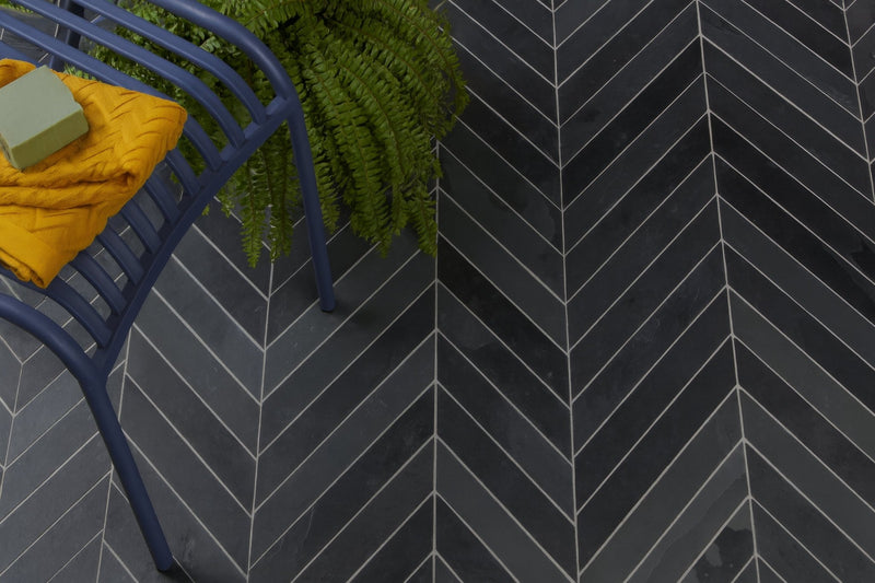 Dark gray herringbone patterned slate bathroom floor tiles with white grout lines for stylish bathroom design