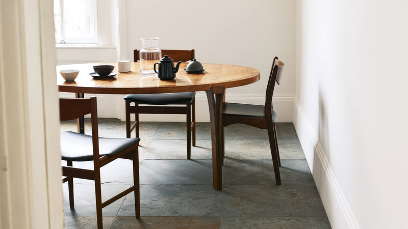 A sleek black ceramic teapot with matching lid on a wooden table from the slate kitchen tiles collection