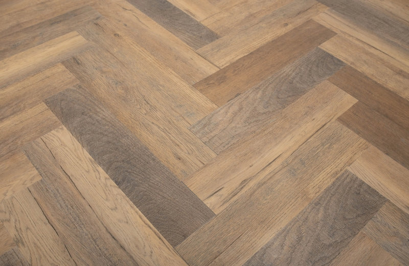 A herringbone-patterned spc flooring with light and dark wood tone hardwood texture.