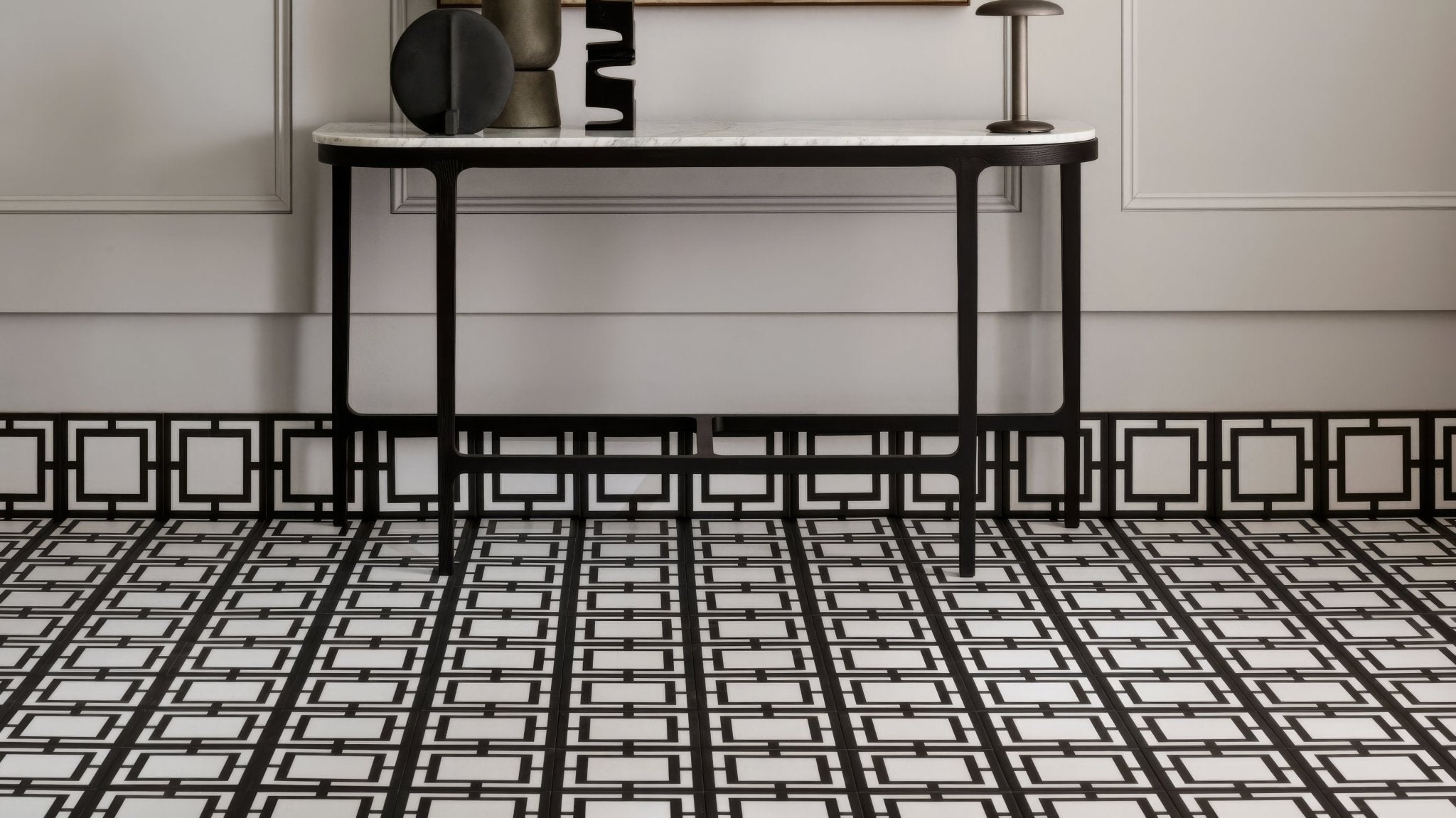 Black and white geometric patterned marble top console table with slender metal legs in square bathroom tiles collection