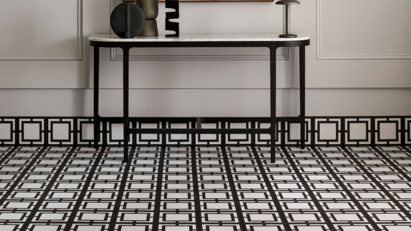 Black and white geometric patterned marble top console table with slender metal legs in square bathroom tiles collection