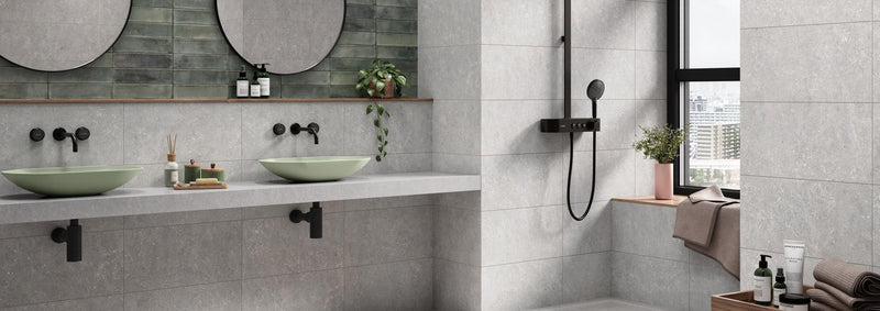 Modern bathroom with two light green ceramic vessel sinks on white countertop and black matte faucets in stone effect tiles