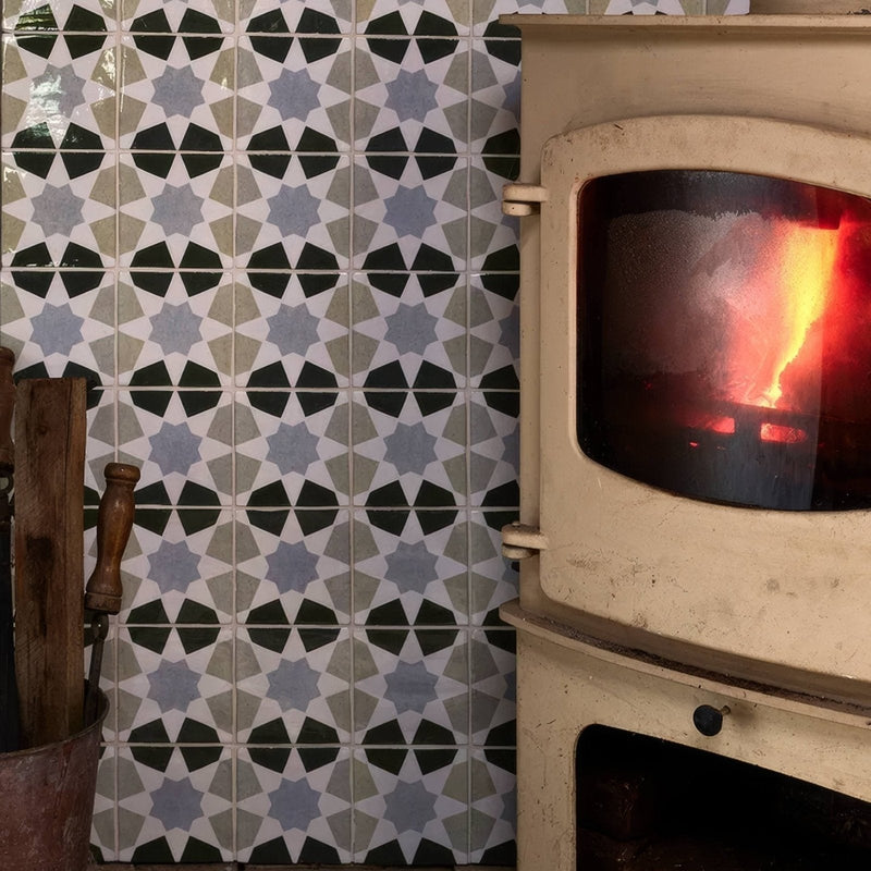 Cream-colored ceramic wood-burning stove with glass door showing glowing embers in studio ceramic collection