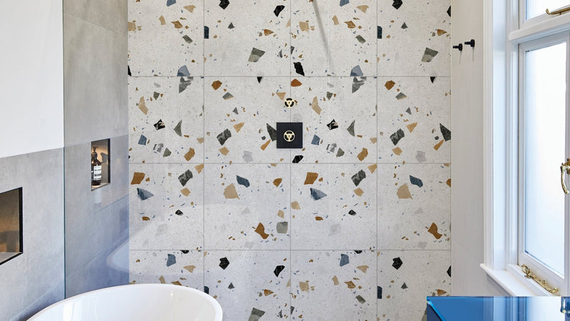 Terrazzo wall tiles with a white base and scattered black gray beige and gold fragments for decorative use