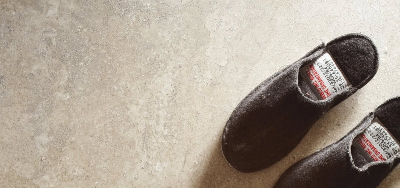 Dark brown felt slippers with soft plush interior and visible brand labels inside the heel in tibur porcelain tiles collection