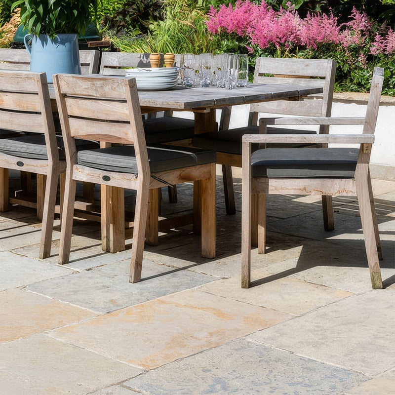 Weathered light wood outdoor dining set with dark gray cushioned seats and matching table from trusloe limestone collection